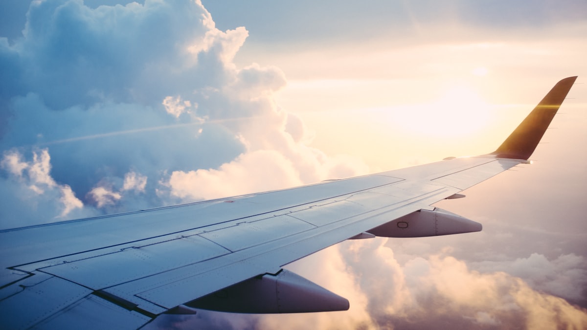 Aircraft wing above clouds at sunset